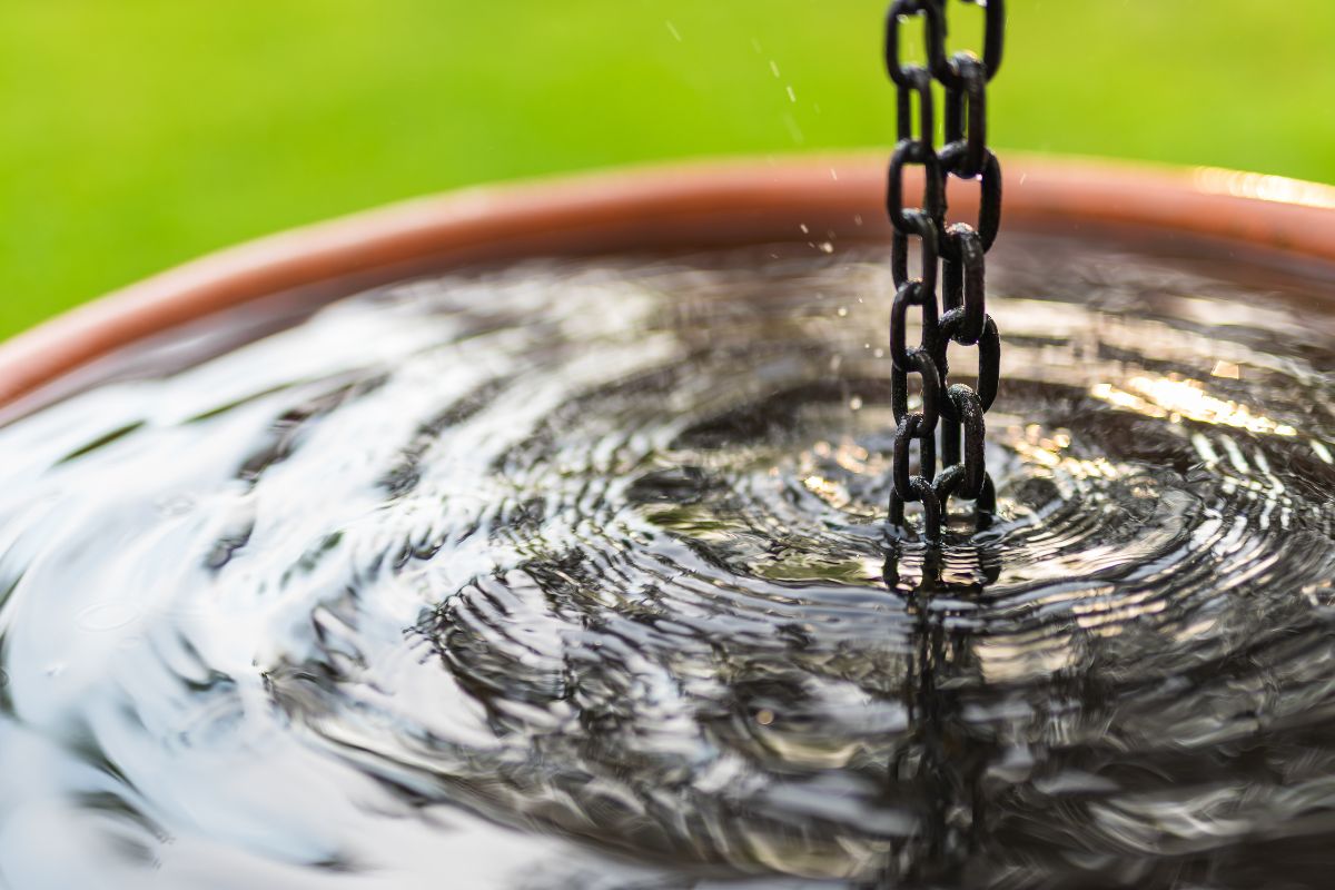 ailed close-up of a water fountain, highlighting the flowing water and an elegant chain intertwined with the structure.